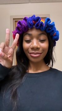 a young woman wearing a crocheted ruffled hat