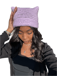 a woman wearing a purple knitted cat hat