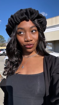 a black woman wearing a black hat