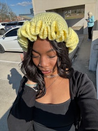 a woman wearing a yellow crocheted hat