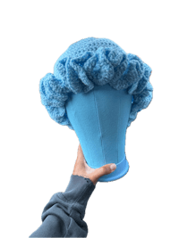 a person holding a blue crocheted hat